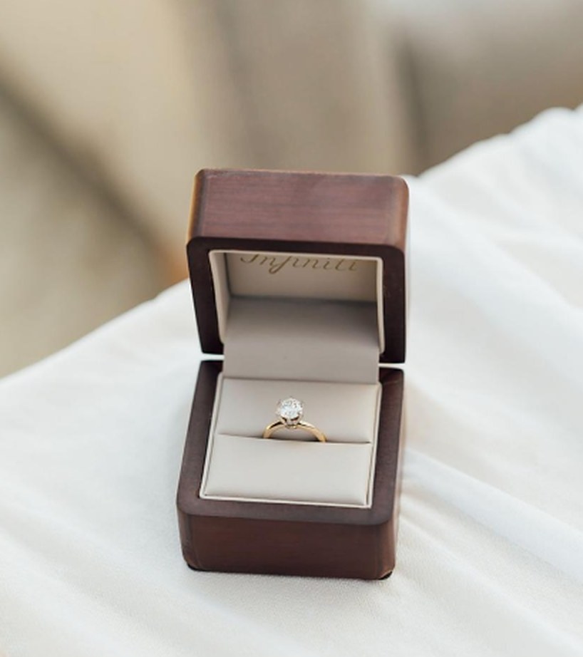 Anillo de compromiso de Infiniti Joyas en oro amarillo con diamante, dentro de su estuche de madera